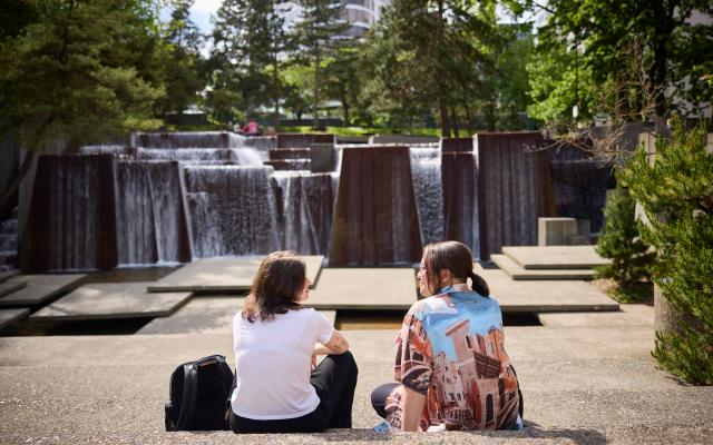 Students sitting in front of fountain