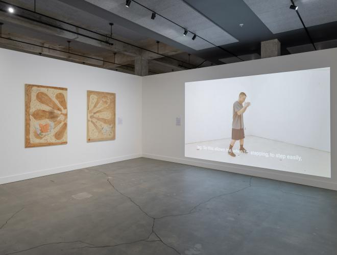 Installation view with video projection by Nolan Hanson textile works by Gigi Woolery.