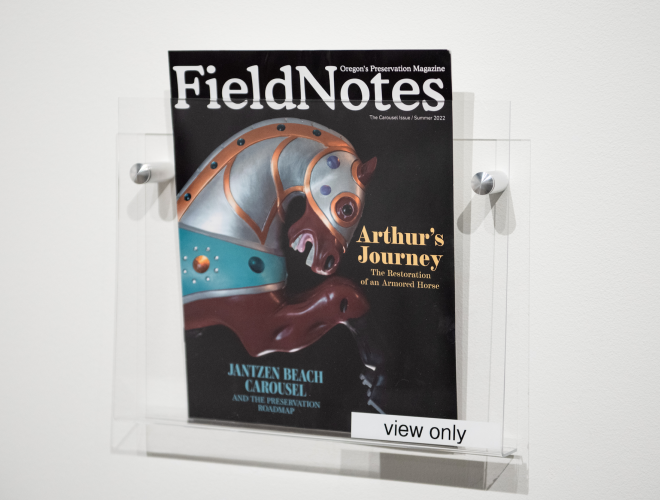 "Field Notes" publication, documenting the Janzen Beach Carousel project, in a plexiglass wall rack.