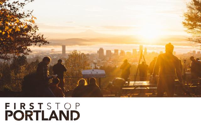 group of people standing around looking out towards the Portland skyline during a sunrise