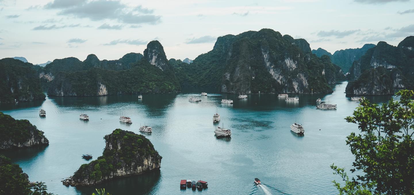 Ha Long Bay in Vietnam with many boats and mini cruise ships in the water