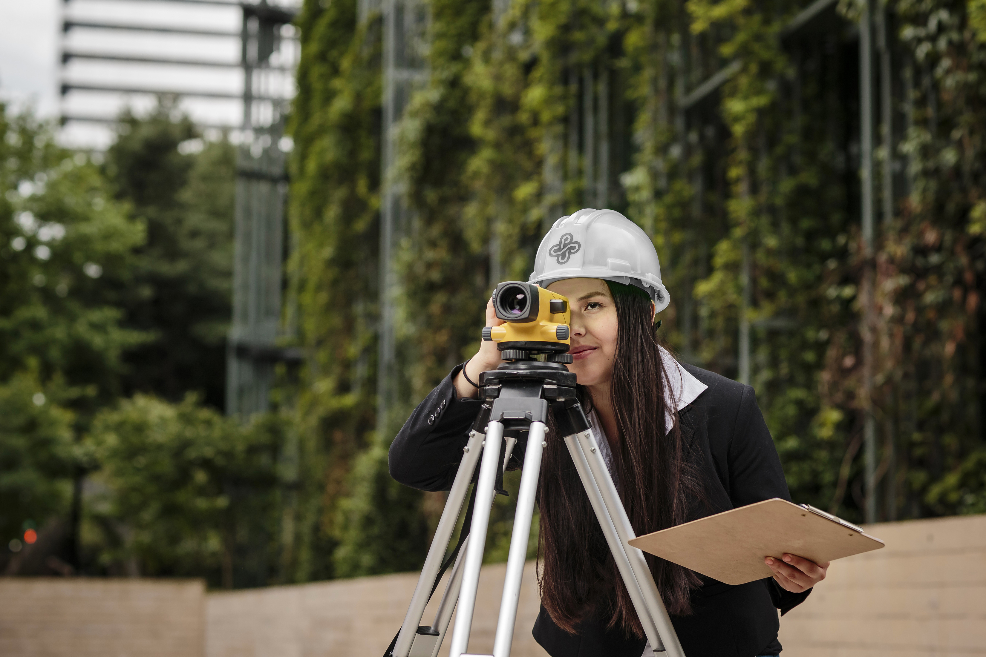 a student looks through the lens of a surveying instrument