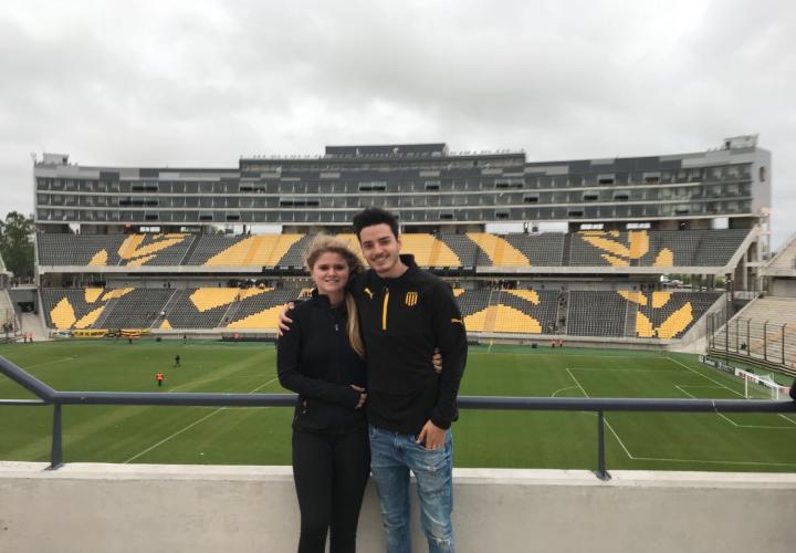 Two PSU students in front of an empty soccer stadium