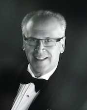 A photograph of Mr. Tom Mason smiling in a tuxedo