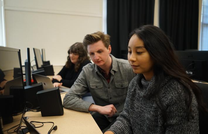 Three students look at monitor