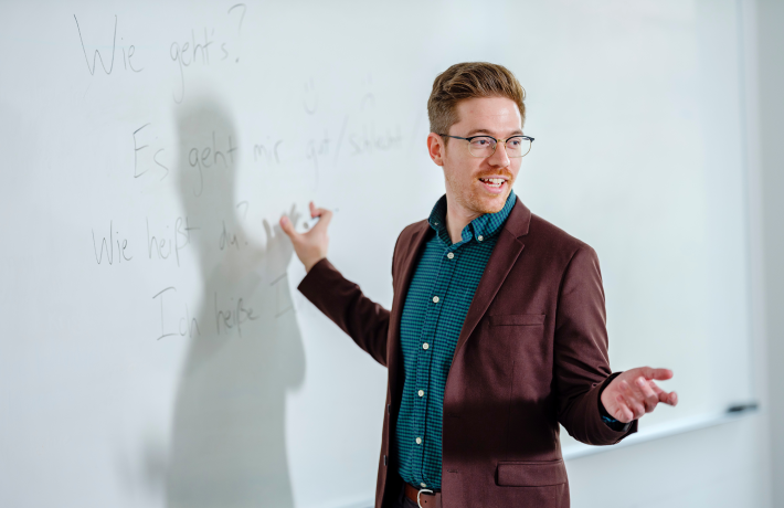 Photo of graduate professor in front of whiteboard