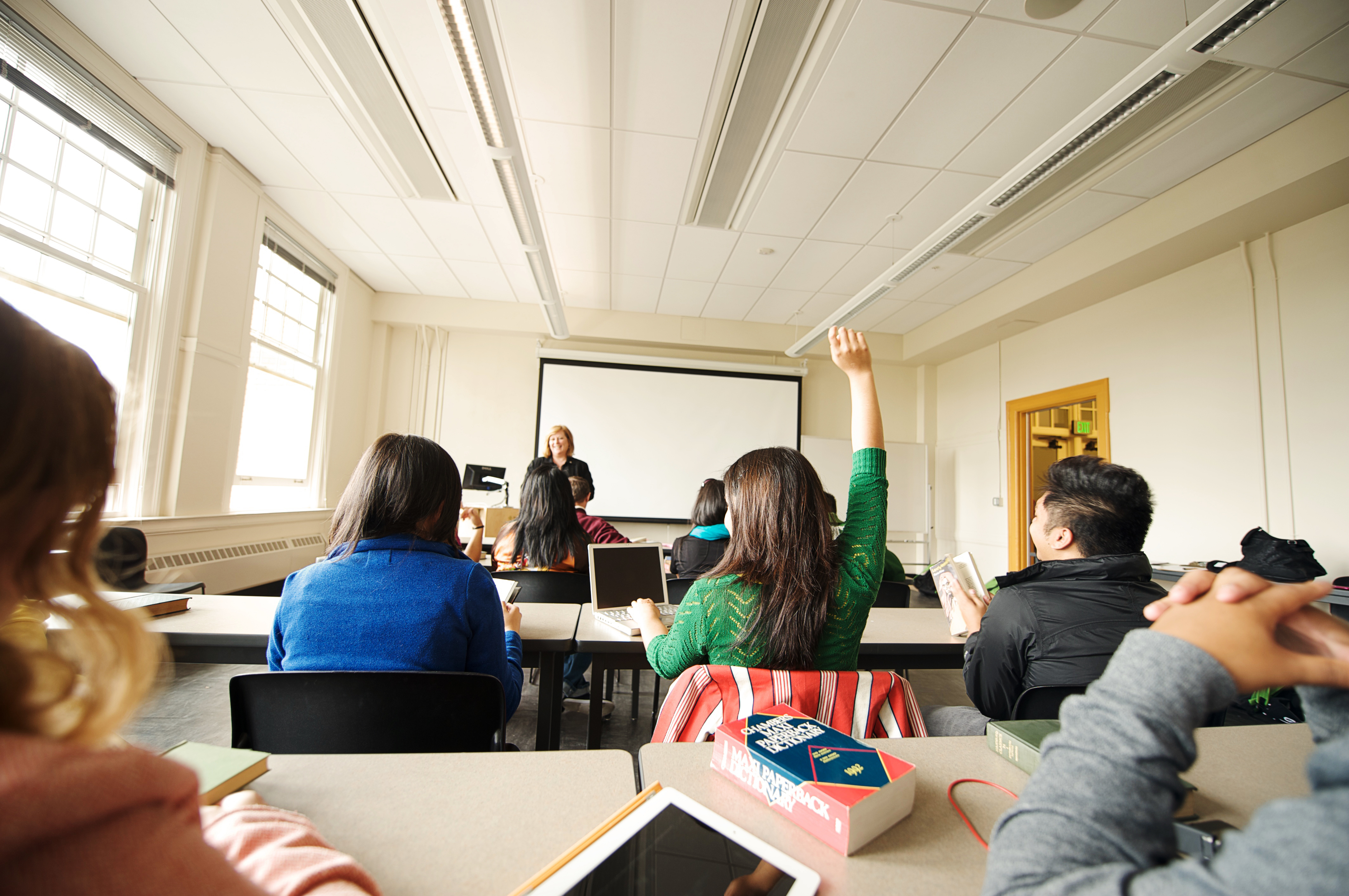Student in classroom raising her hand