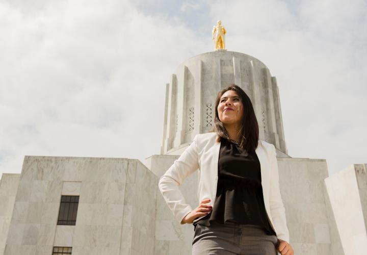 Photo of a Latina woman standing in front of the Oregon state capital looking like a boss.