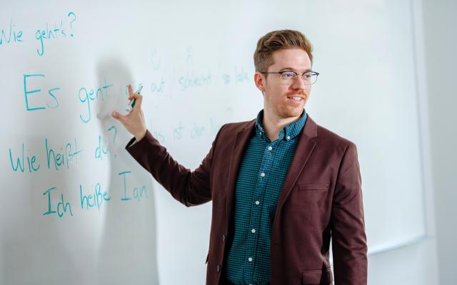 Man standing in front of whiteboard with German words