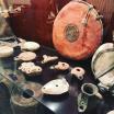 Ancient oil lamps on display in a glass case with other leather historical objects.