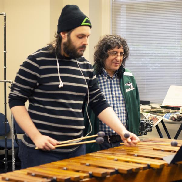 Percussion student and instructor in rehearsal