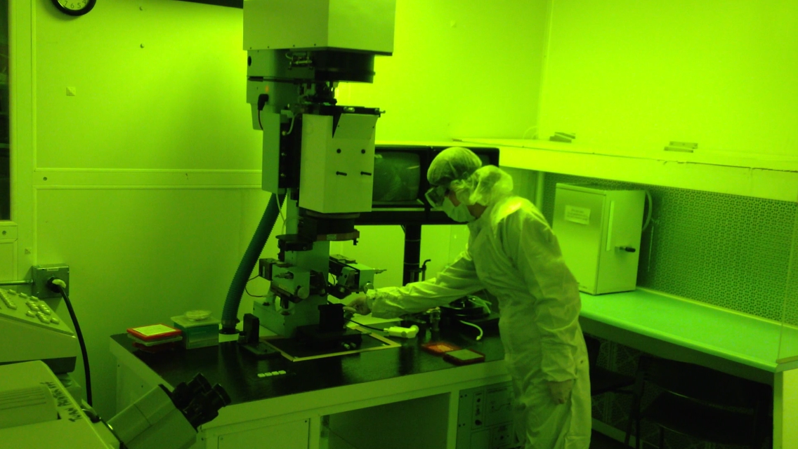 Student loading silicon wafer onto clean room aligner
