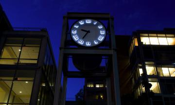 Clock in Urban Plaza against a late night or early morning sky. 
