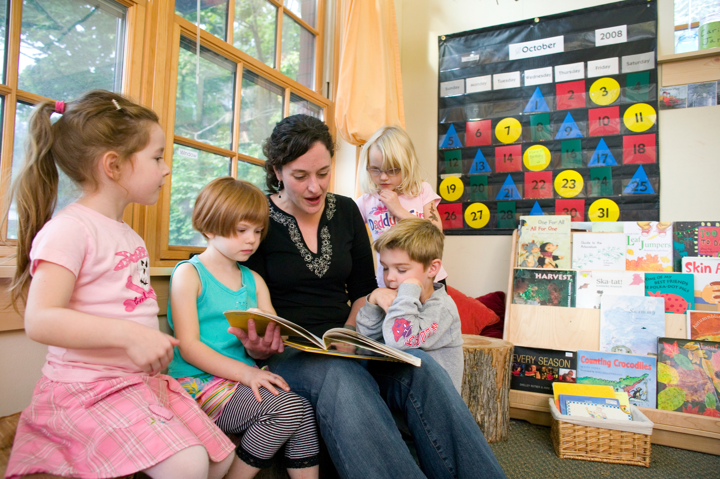 Teacher reading book to young children