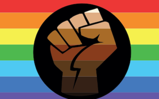 rainbow flag with a black and brown fist in the center