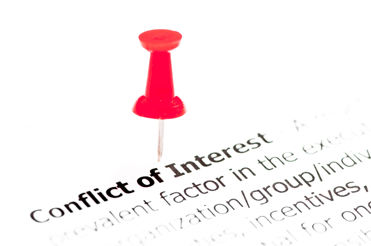 Conflict of interest document with red push pin.