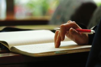 Close up of a student writing in a notebook