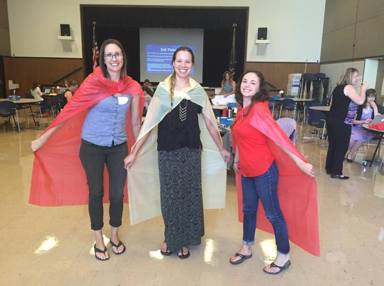 Three females posing with capes 