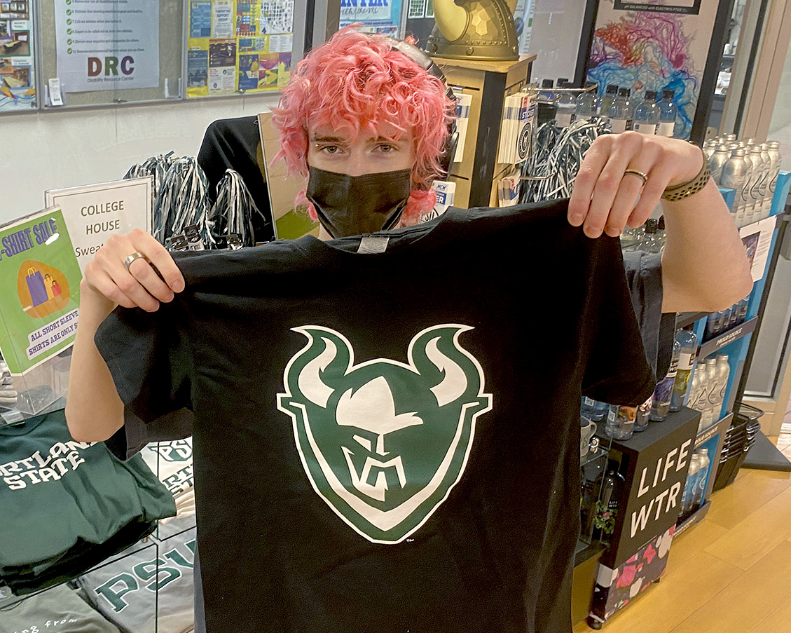 Student holds a P S U t-shirt on sale in the University Market.