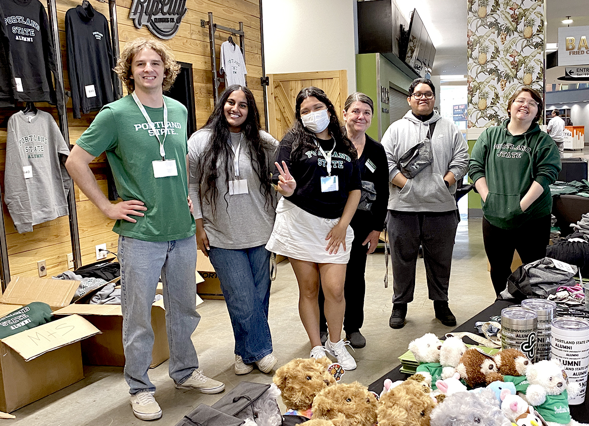 Staff members of the University Market pose with some of the Portland State gear and merchandise available at the Market.