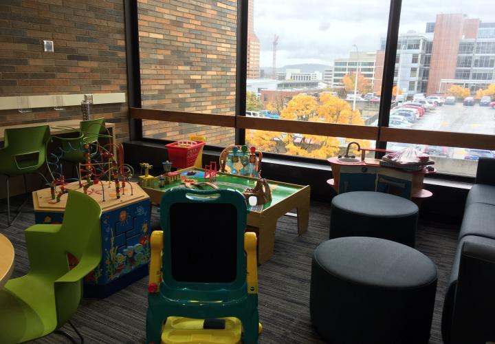 A family friendly study space with a lot of children's toys, foot rests, and a study area.