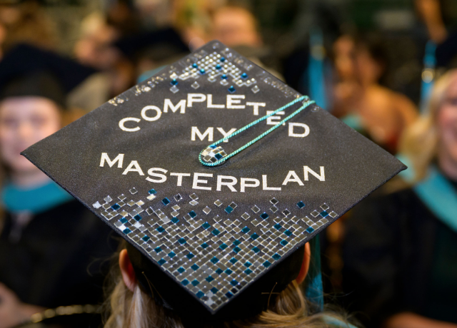 Photo of the top of a graduation cap with the decoration "Completed my masterplan"
