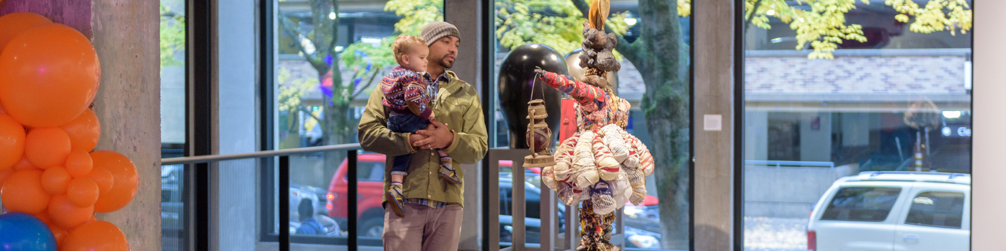Student and his child looking at art in the Museum on campus