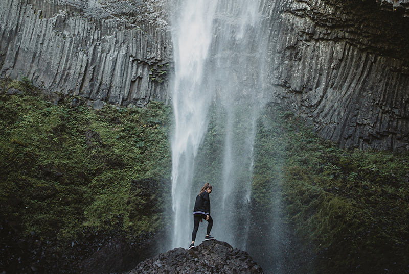 Portland State student hiking near a waterfall