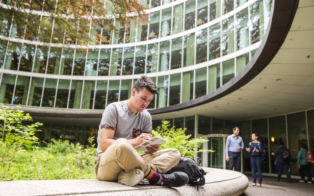 Student sitting outside of library