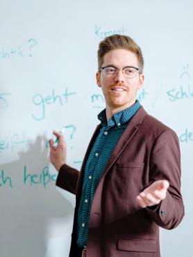Professor writing German on a white board