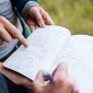 Two students collaborating over a journal.