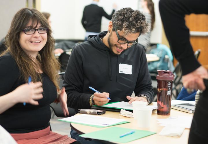 graduate students working and smiling at conference