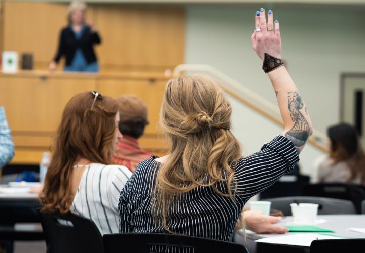 PSU graduate student raising hand in conference