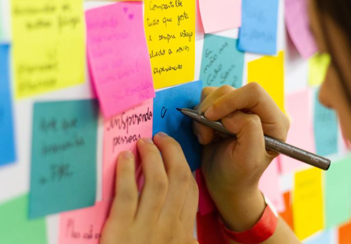 person writing on sticky notes