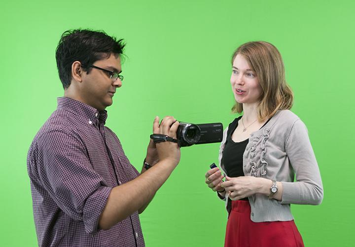 faculty filming against the green screen