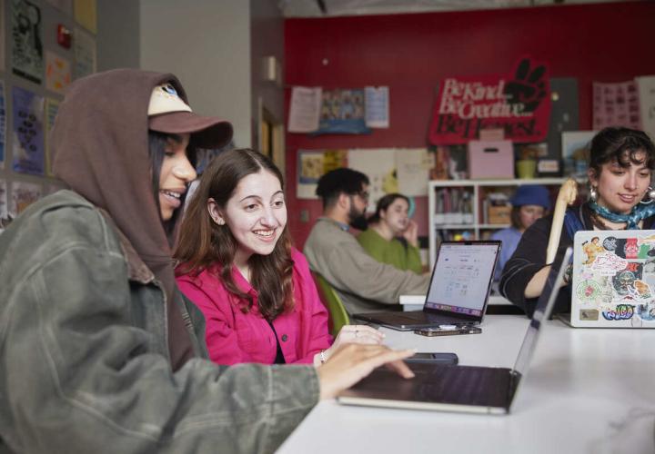 Faculty and student looking a digital course materials together in a classroom