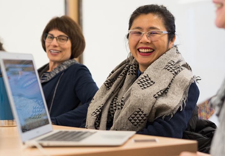 Faculty smiling at desk