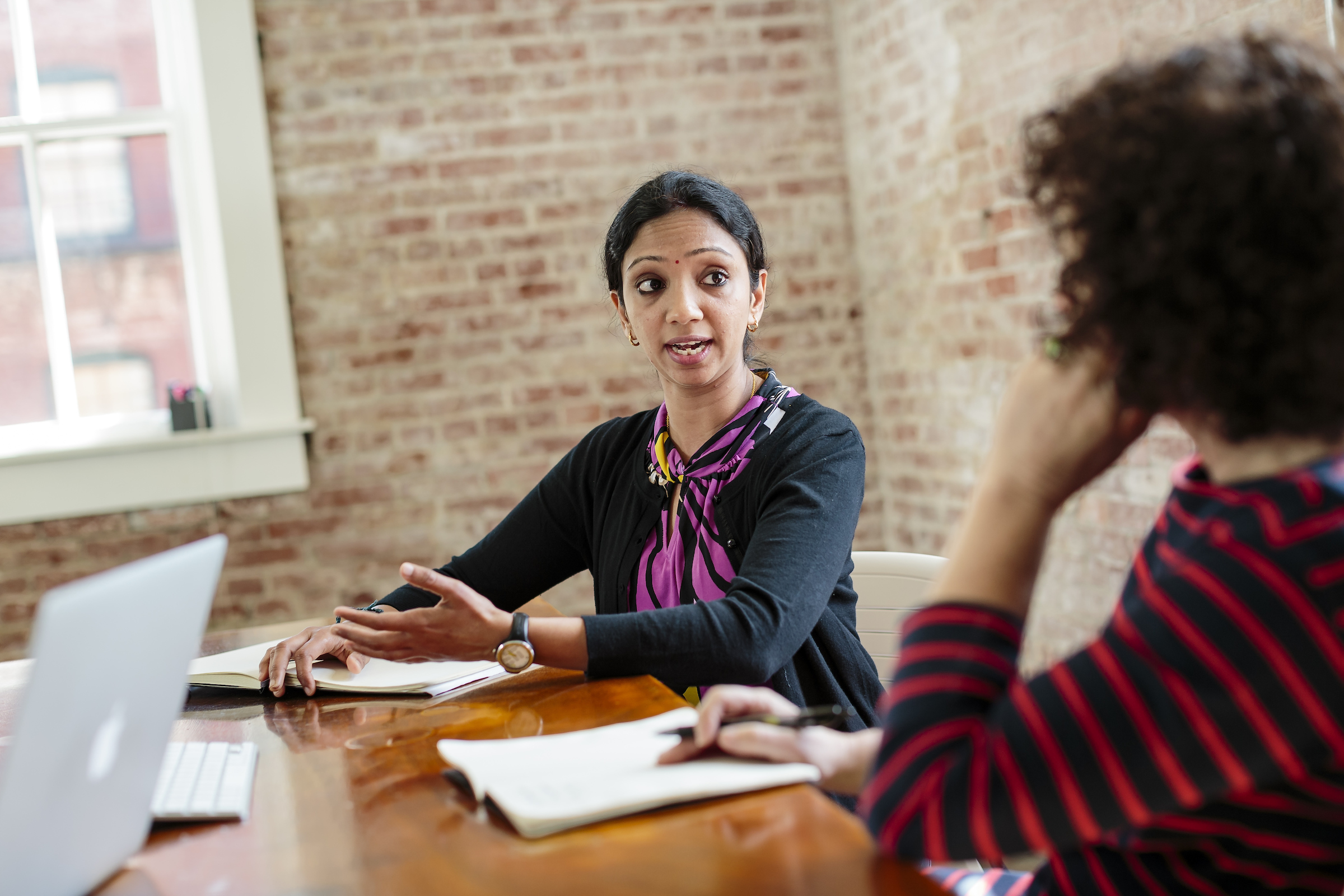 Two people chatting at a desk