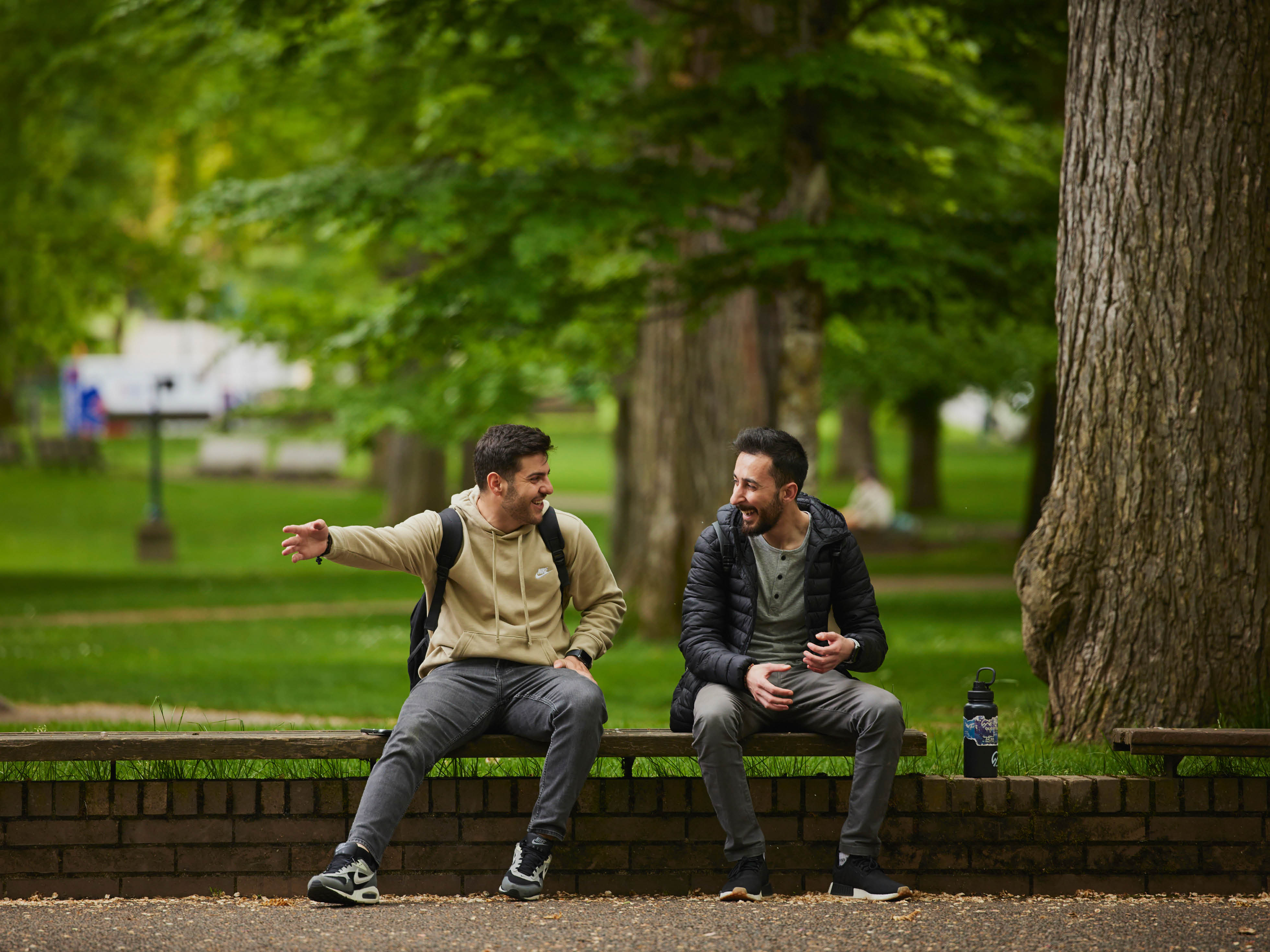 Students talking to each other on a bench in the Park Blocks