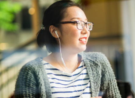Student listening to her headphones at Starbucks