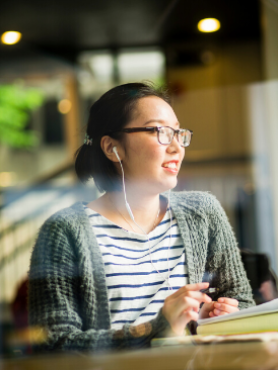 Student listening to her headphones at Starbucks