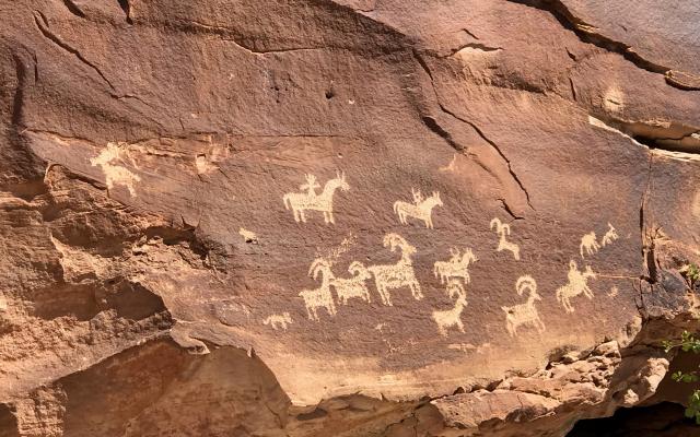 rock face with petroglyph depicting four-legged horned animals