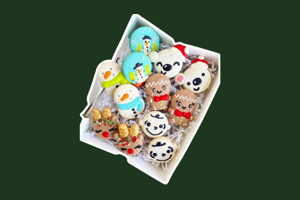 Gift box of holiday macarons in decorated like snowmen, reindeer and gingerbread men.