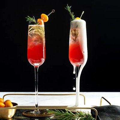 Two champagne flutes with Holiday spritz cocktail in them