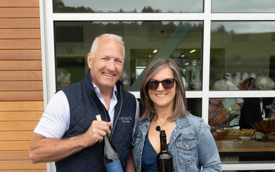 Kim and Christian of Caelestis Cellars, posing with one of their wine bottles at the 2025 Vikings on the Vine Winemaker's Tasting event.