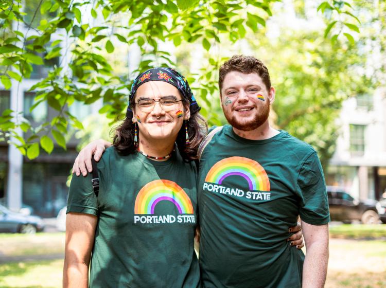 Two folks posing in their matching PSU pride shirts at the Pride Parade.