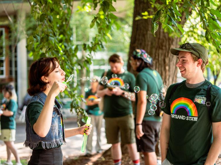 A person blowing bubbles at another person 