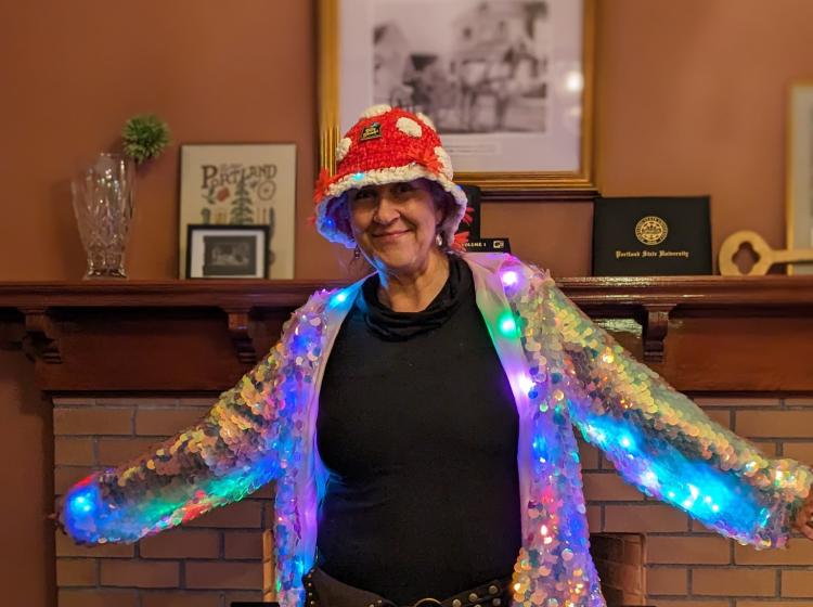 Women dressed in a light-up jacket posing inside the Simon Benson House,