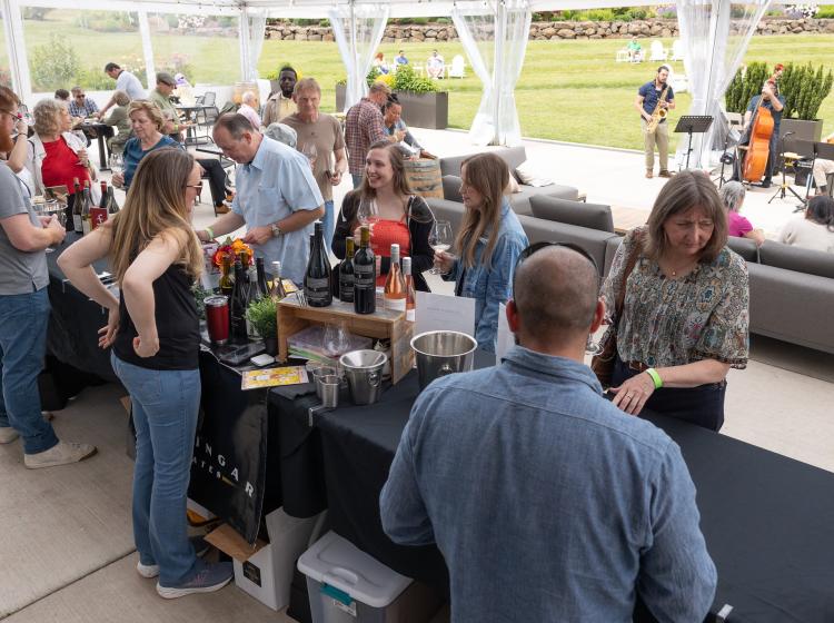 People mingling and tasting wine from alumni-owned wineries, Eagles Nest and Bellingar Estate.