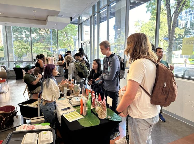 PSU community visiting with an alum business owner at the Viking Made pop-up market on campus.